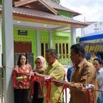 Camat Montalat Hakim, didampingi kepala Desa Ruji Utuh Jaya saat memotong pita dalam rangka peresmian kantor desa ruji dan kanto BPD (foto : Candra).